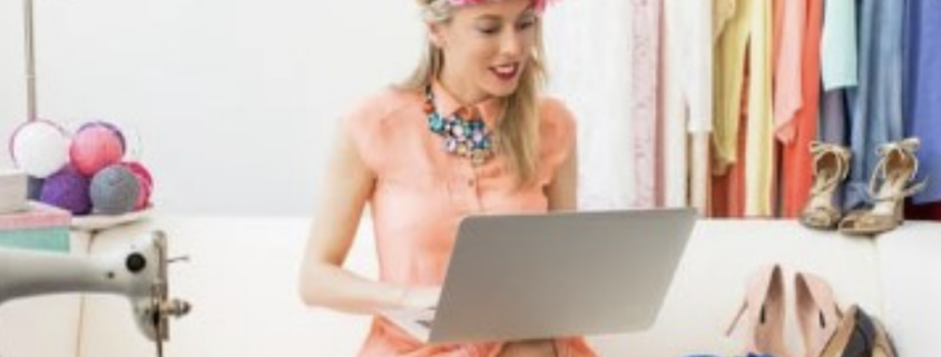 Fashion designer working on a laptop, surrounded by garments and accessories, illustrating the importance of cybersecurity in protecting digital design assets and confidential fashion data.